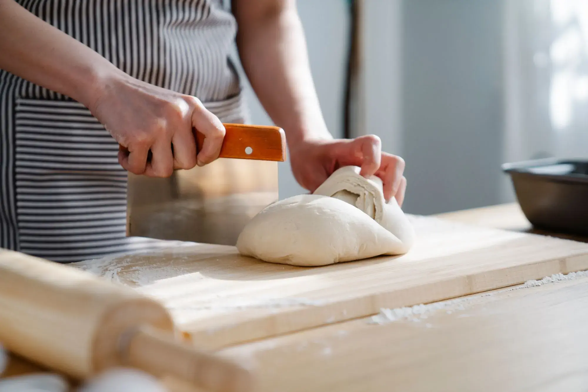 Dough being cut on a floured board