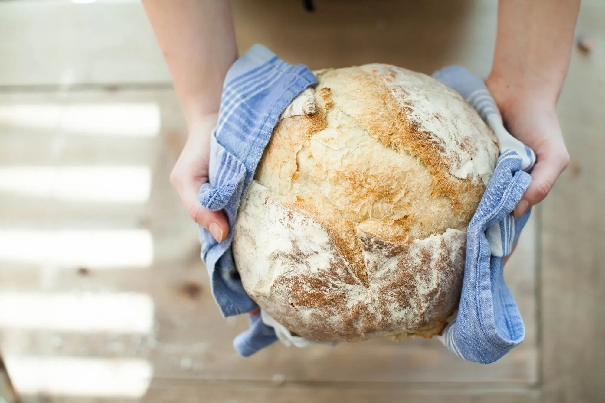 A fresh loaf wrapped in a tea towel