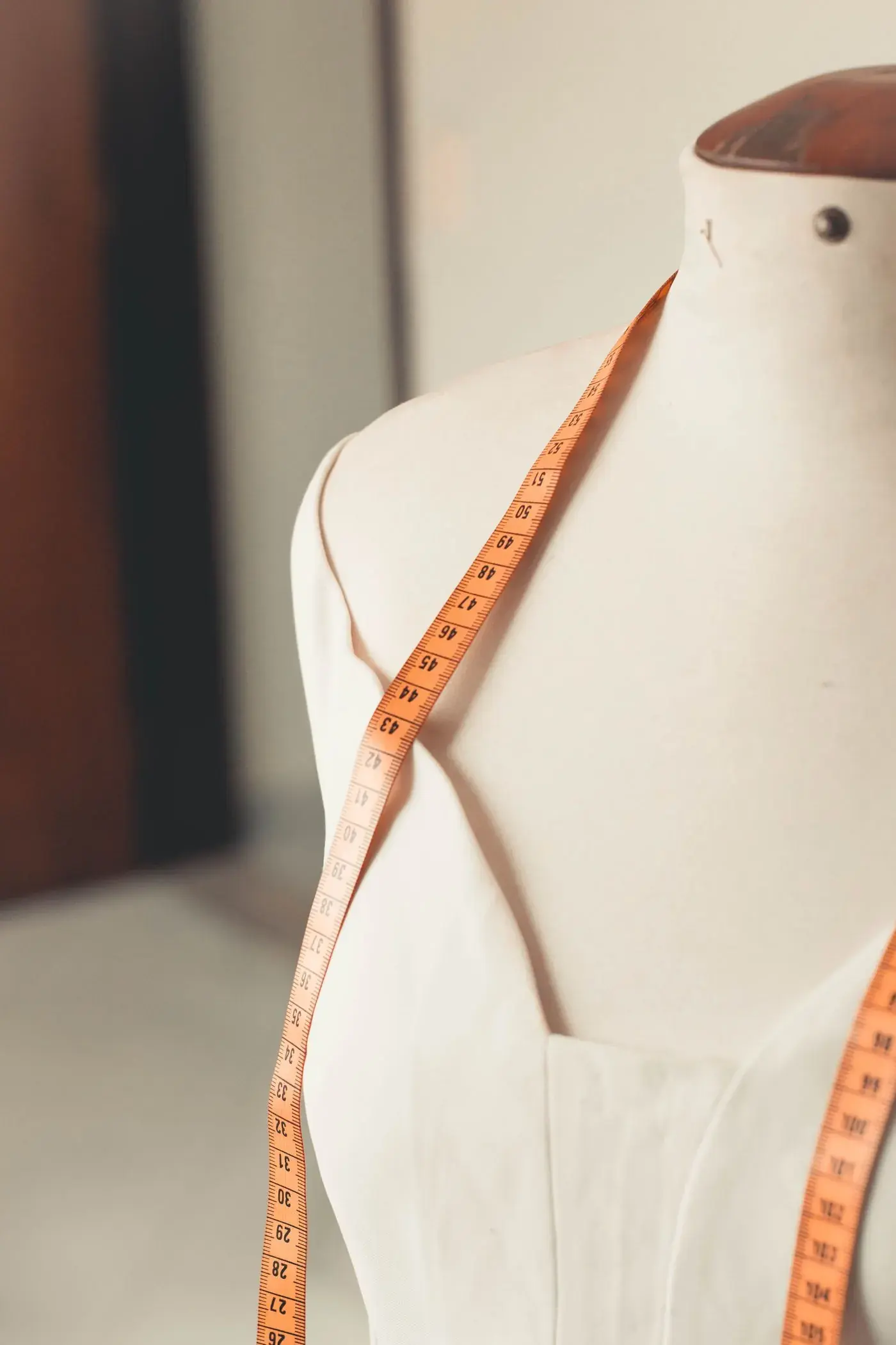 A tape measure draped over a dress form