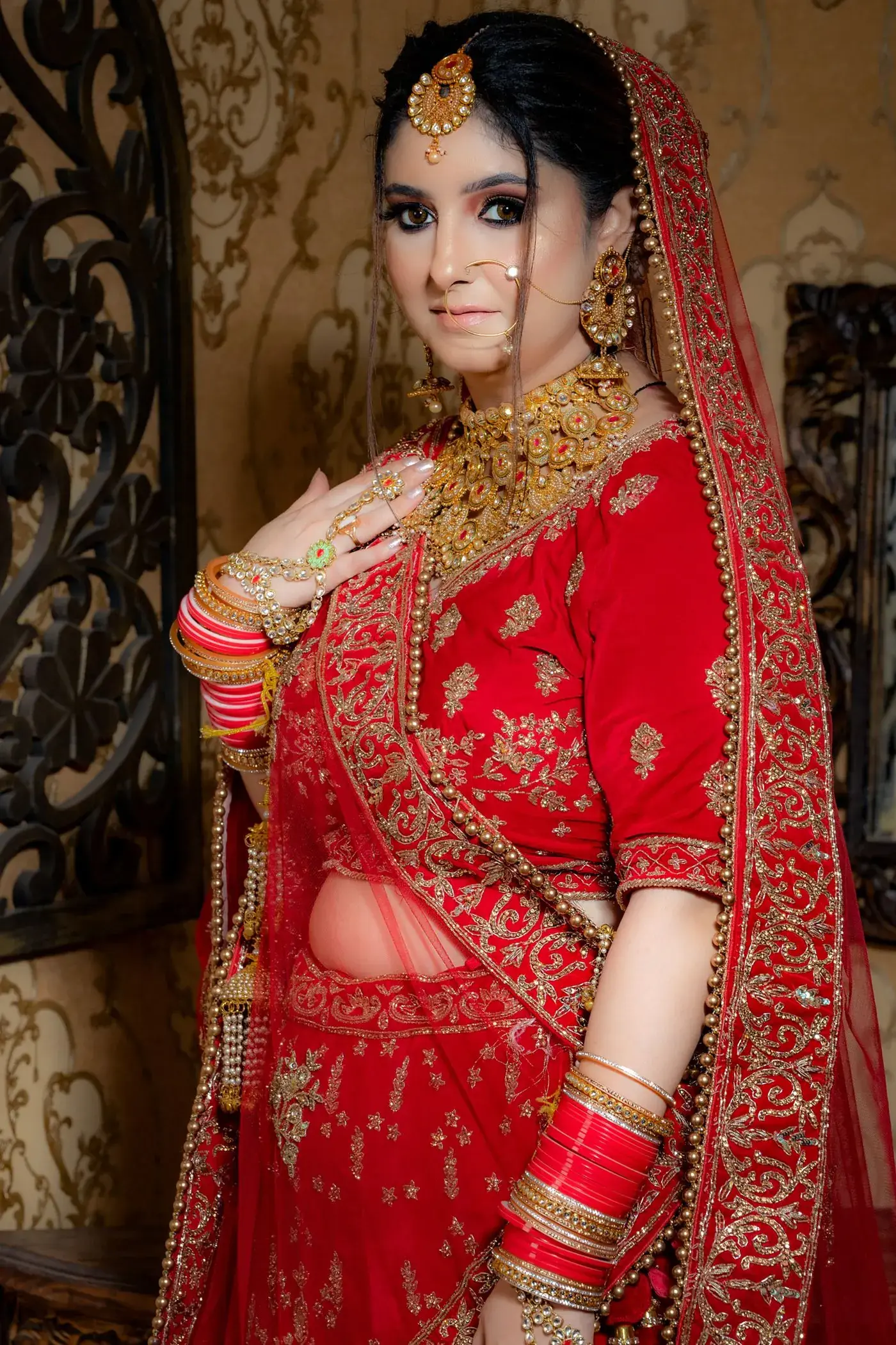 A bride in a red and gold lehenga