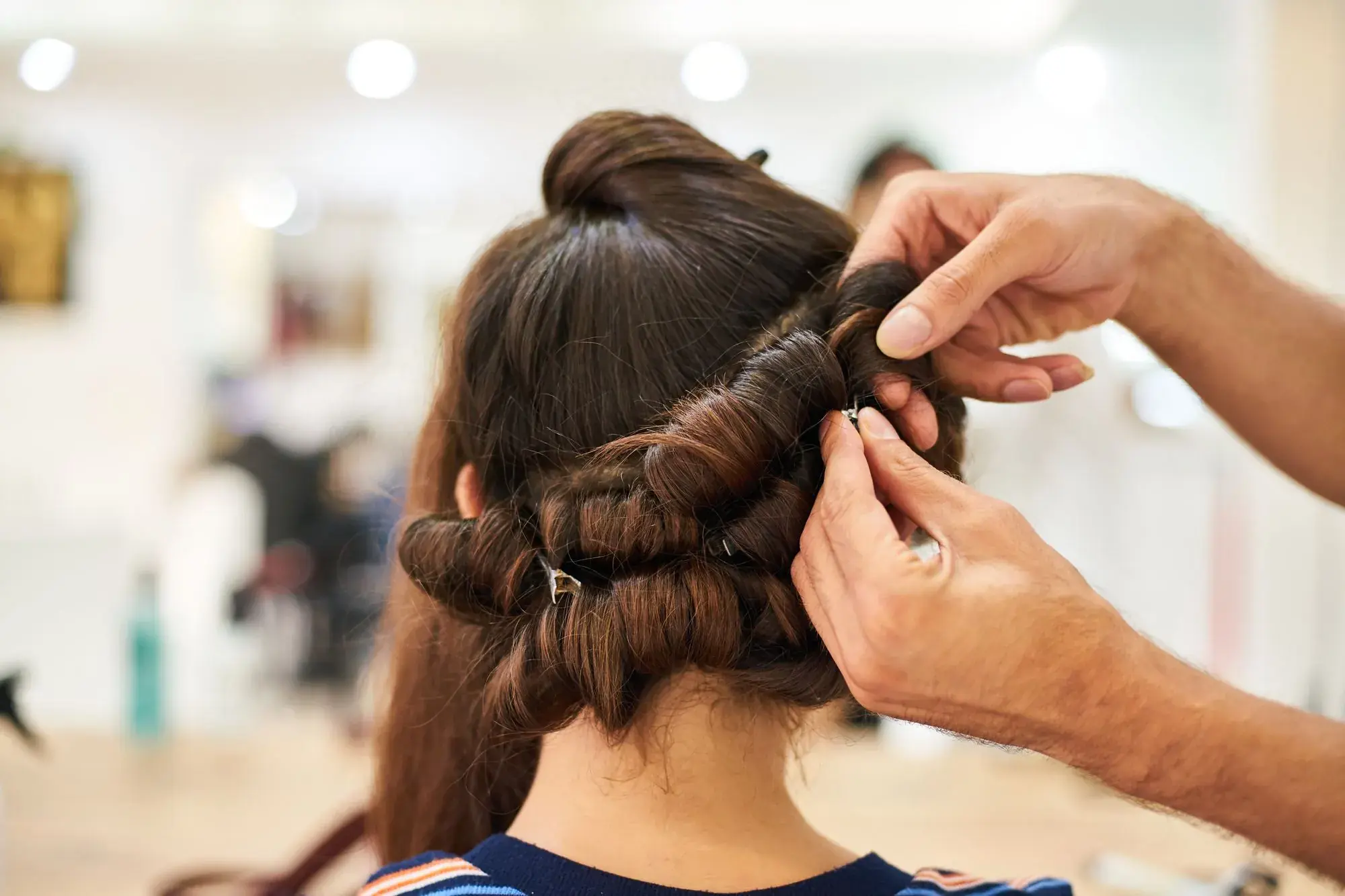 A stylist pinning an updo into place